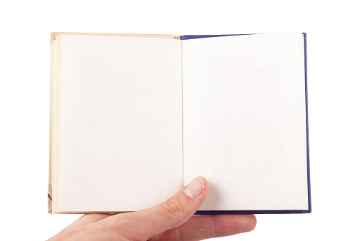 Hand holding a small size open book, handbook with empty blank white pages, front view, frontal shot, closeup. Object isolated on white background cut out Copy space, reading pocket notes blank pages