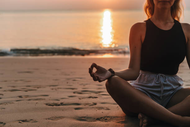 istock Young woman practicing yoga on the beach 1702741303