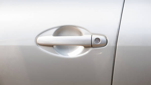 istock Simple generic silver car door handle with a key lock hole, side front view, object detail, closeup, vehicle doors handle frontal shot. Car safety, security locking the doors abstract concept, nobody 1702743018
