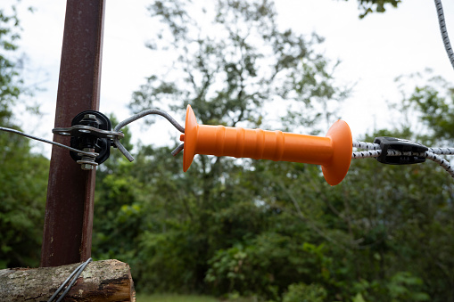 Heavy Duty Gate Handle mounted on a shock-current cable fence to deter wildlife from entering the plantation.