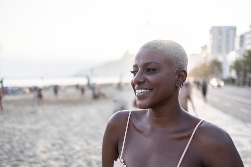 Smiling black woman at the end of the afternoon at the beach