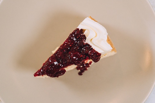 A white ceramic plate with a freshly cut slice of pie resting on top of it