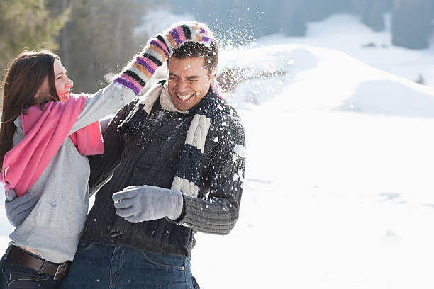 casal com guerra de bolas de neve - snowball snow play throwing - fotografias e filmes do acervo