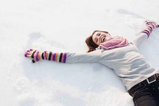 Woman making snow angel  snow angels stock pictures, royalty-free photos & images