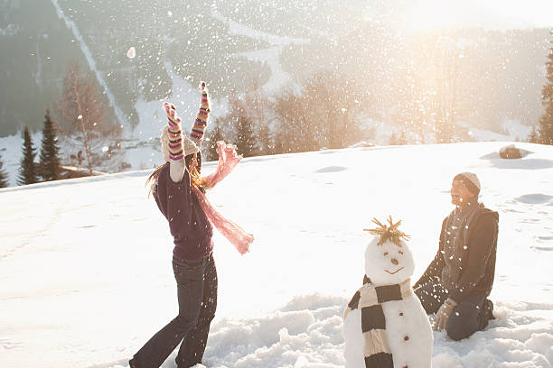 casal com guerra de bolas de neve - snowball snow play throwing - fotografias e filmes do acervo