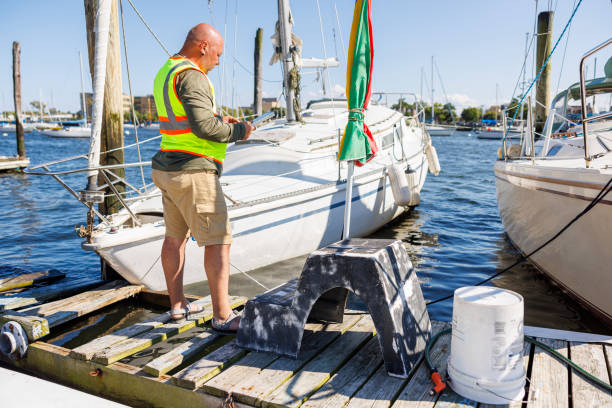 istock Drowning ship bow inspection.
Mature bald inspector with digital tablet assessing yacht prow in a pier 1702805988