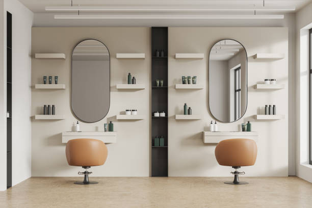 istock Beige salon interior with chairs in row and cosmetics on shelf, window 1702829520
