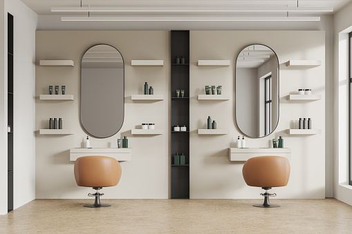 Stylish beauty salon interior with spinning armchairs in row on beige concrete floor. Oval mirrors and mounted shelves with cosmetics. Elegant workshop with furniture and accessories. 3D rendering