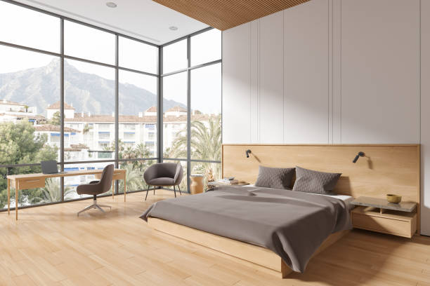 istock Stylish home bedroom interior with bed and work zone, panoramic window 1702829788