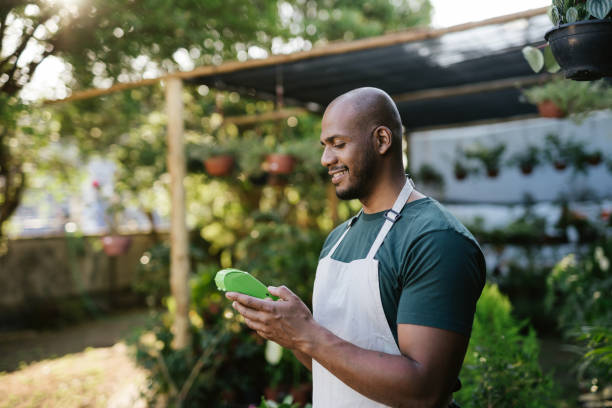 istock Garden store owner holding credit card machine 1702831957