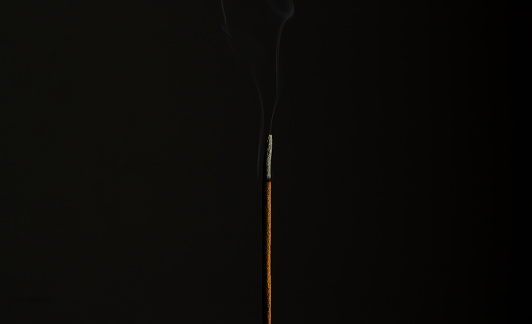 Incense stick burning in the dark.