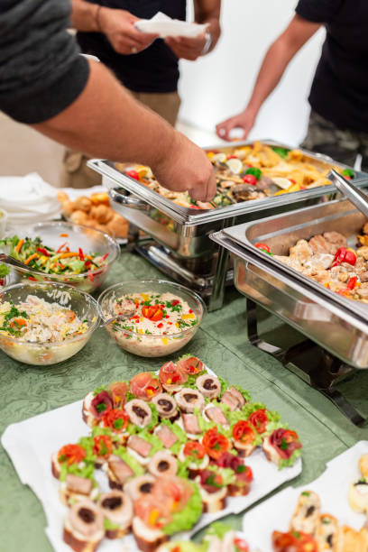 istock People picking up food from buffet catering table. 1702859427