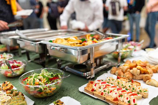Close up of buffet table food in chafing dish at celebration event.