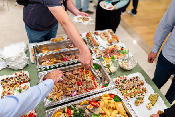 istock Hands picking up food from buffet catering table at the party. 1702859950