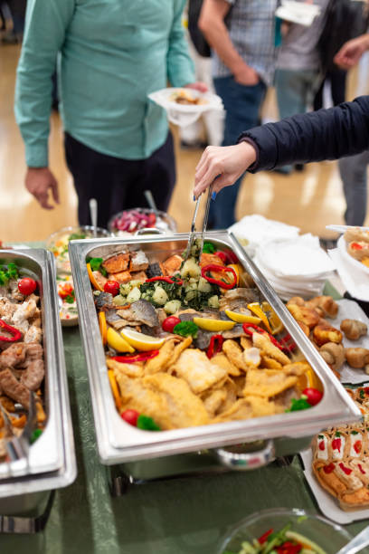 istock Man scooping seafood from warming tray. Health meal buffet lunch. 1702859993