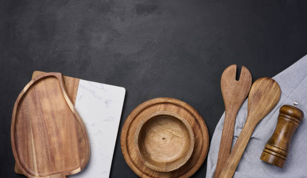 istock Empty bowl and wooden spoons on a black table, top view 1702872453