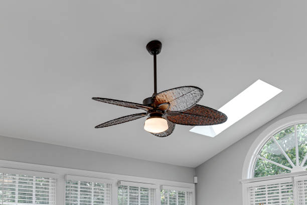 istock Woven Elegant Ceiling Fan Light Fixture in Sunroom Interior with White Ceiling and Arch Window 1702880739