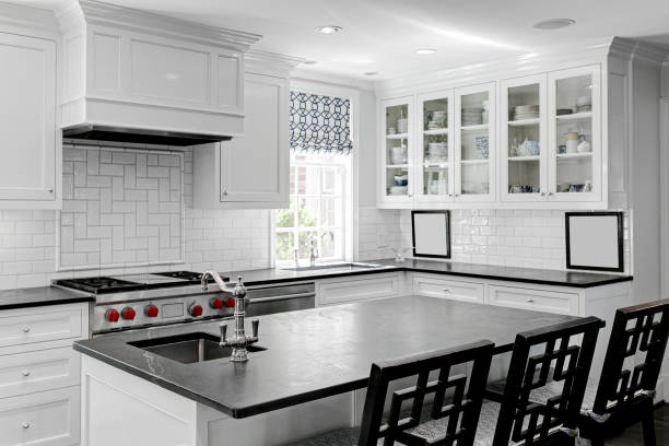istock Luxury White Modern Kitchen Interior with White Cabinets with Gas Stove and Black Stone Counters 1702882822