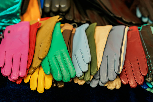 Set of colorful multi-colored leather gloves on dark background
