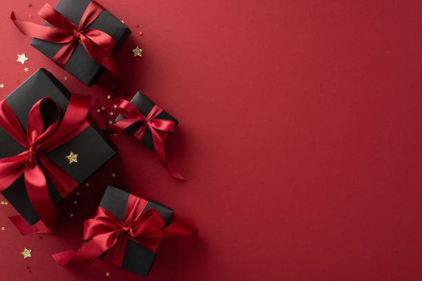 istock Black Friday elegance: Top-view shot of exquisite black gift boxes, complemented by vine-colored ribbon bows, shiny confetti on marsala backdropâsymbolic of unbeatable deals, space for promotion 1702909652