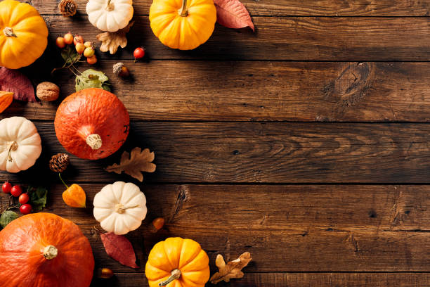 istock Happy Thanksgiving day background. Autumn frame with pumpkins, fall leaves, berries, walnuts, acorns on wooden table. Flat lay, top view, copy space. 1702934416