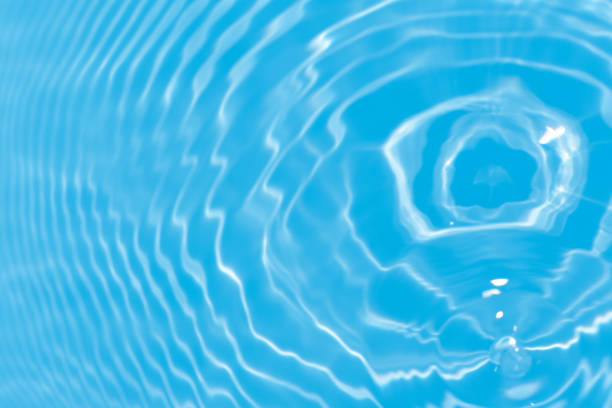 istock Defocus blurred transparent blue colored clear calm water surface texture with splashes reflection. Trendy abstract nature background. Water waves in sunlight with copy space. Blue watercolor shine. 1702979520