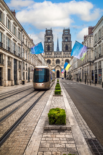 Orleans, France - August 10, 2023: Street of Orleans, modern tram, and cathedral of the holy cross.