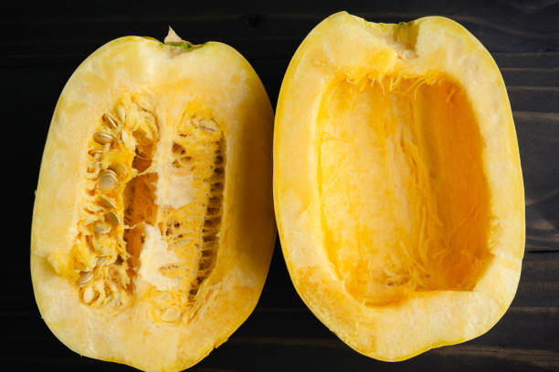istock Halved spaghetti squash with and without seeds close-up on a wooden table 1702985074
