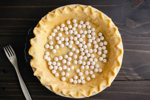 istock Unbaked Pie Crust Dough with Pinched Edges in a Pie Pan with Pie Weights 1702986703