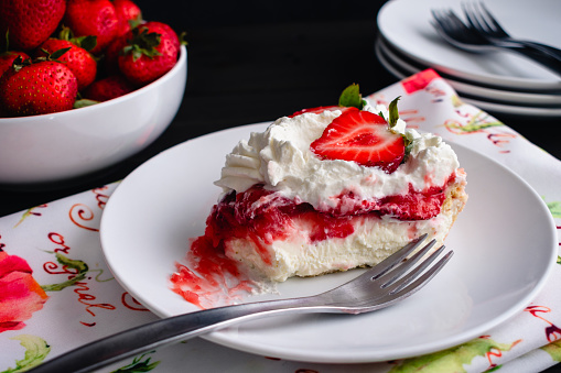 Piece of strawberry pie on a small plate with a bite taken out