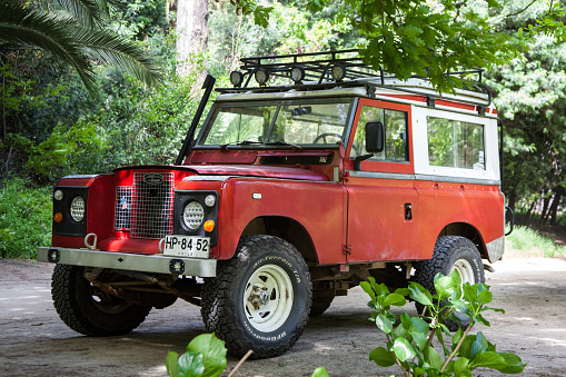 Münsingen, Germany - May 1, 2023: Land Rover Defender British oldtimer vintage off-road utility car on a country road on a sunny summer day.
