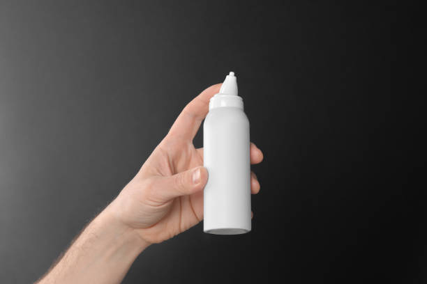 istock Man holding nasal spray on black background, closeup 1703048009