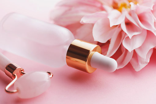 Organic face serum and jade roller with big pink flower