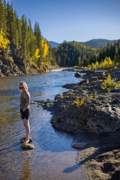 istock Woman explores riverbank in autumn 1703103792