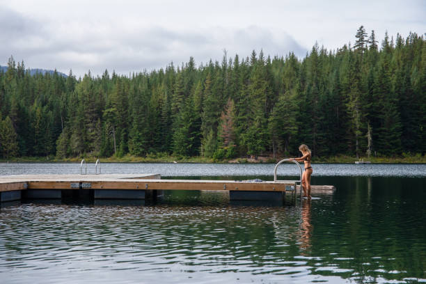 Young woman climbs onto pier