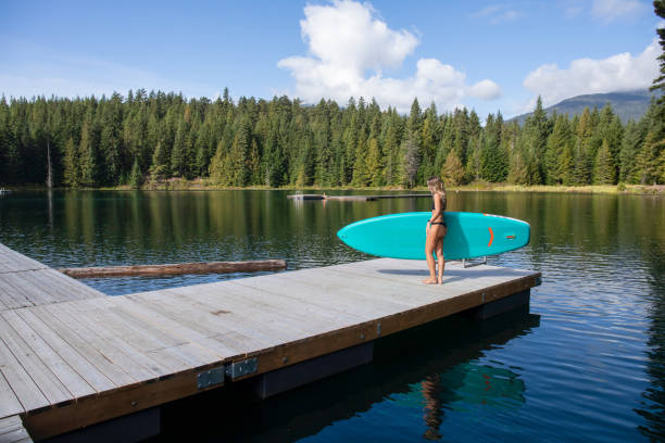 istock Woman prepares to go stand up paddle boarding (SUP) 1703109479