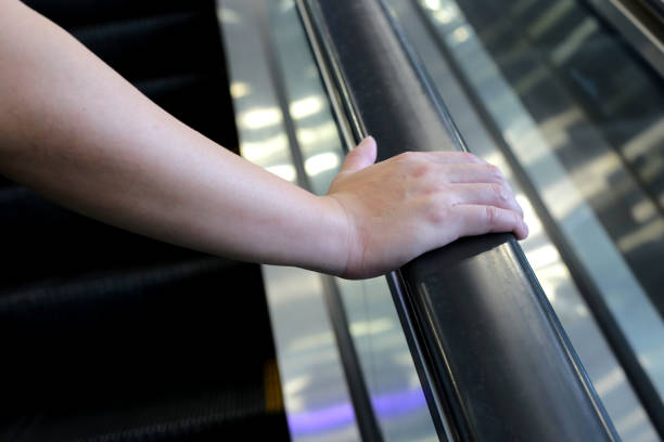istock Hand holding escalator handrail in shopping mall or building 1703114396