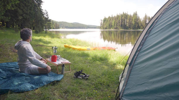 istock Breakfast in nature. Solo traveler camping with kayak. 1703120464