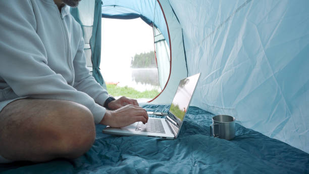 istock Digital nomad working in tent while camping in nature. 1703120766