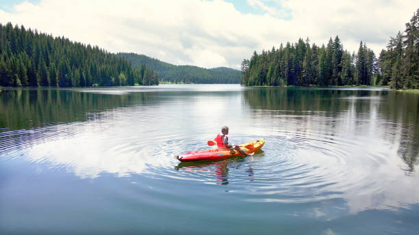 istock Solo traveler kayaking and camping in nature. 1703121021