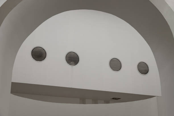 Sunlight shines through white arch interior design and white cement wall.