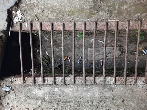 The drain was metal and there was some rubbish in it