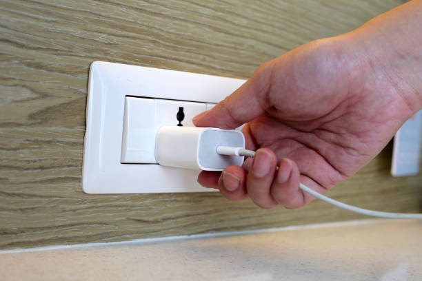 istock Hand insert a plug of the phone charger into socket. 1703154899