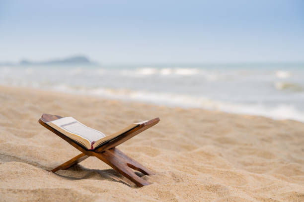 istock Vintage lantern and Holy Quran on sand. 1703184051