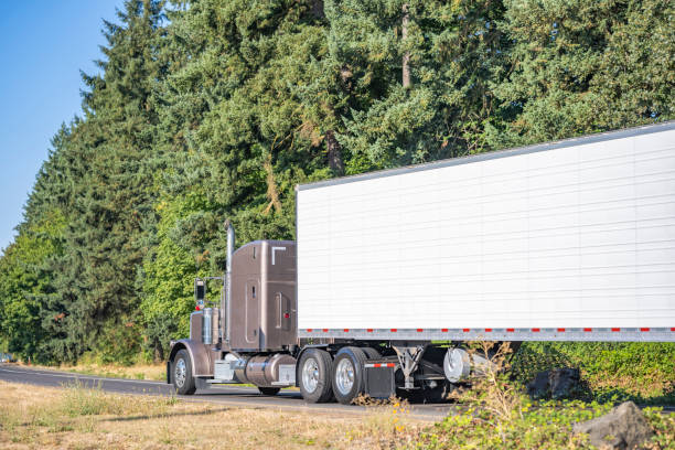 istock Classic light brown bonnet big rig semi truck transporting cargo in refrigerator semi trailer running on the highway entrance road 1703207490