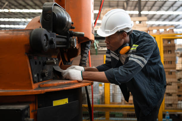 istock African American technician craft man control and checking machine at wood factory 1703214478