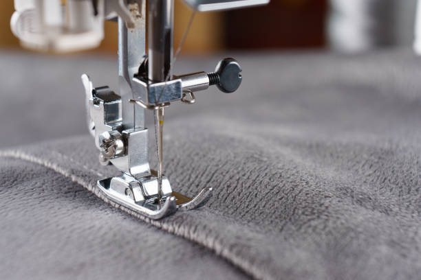 istock Modern sewing machine with gray velours fabric close up 1703214565