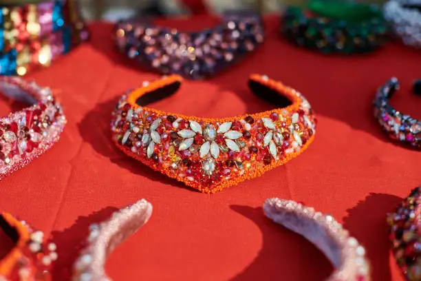 Different traditional russian headwear exhibition, decorative headbands decorated colorful jewelry on red table, russian headdresses beaded sparkling jewelry, beautiful russian headband