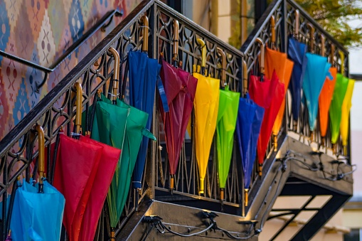 Multi-colored umbrellas hanging on the staircase railing