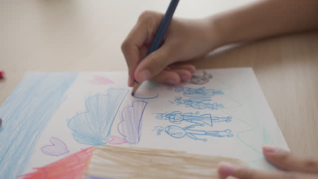 Close-up of a child hands coloring and drawing with a colored pencil